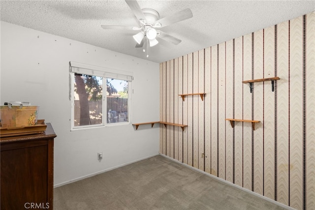 spare room with ceiling fan, light colored carpet, and a textured ceiling