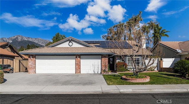 single story home featuring a mountain view, solar panels, and a garage