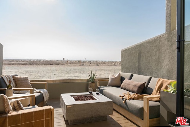 view of patio / terrace featuring an outdoor living space with a fire pit and a water view