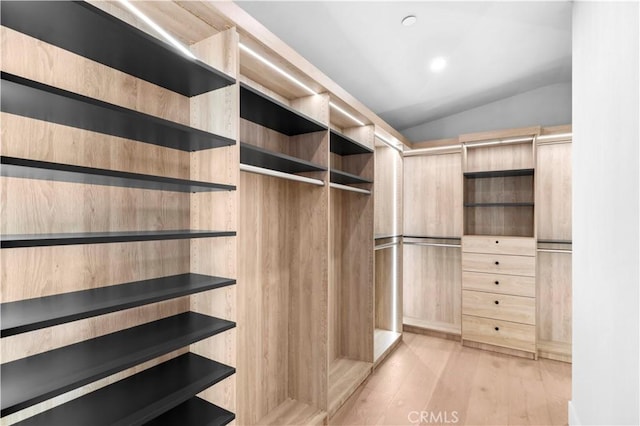 spacious closet with lofted ceiling and light hardwood / wood-style floors