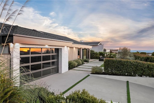 property exterior at dusk featuring a garage