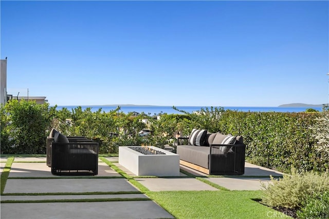 exterior space featuring a water view and an outdoor living space with a fire pit