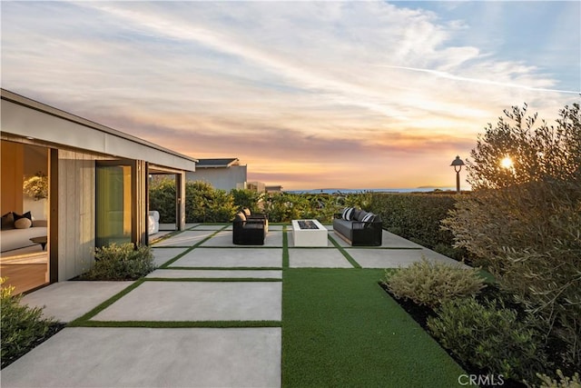 patio terrace at dusk featuring an outdoor hangout area