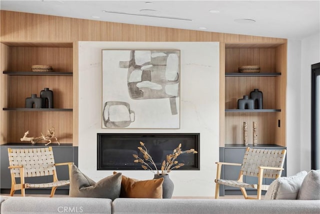 living room with vaulted ceiling and built in shelves