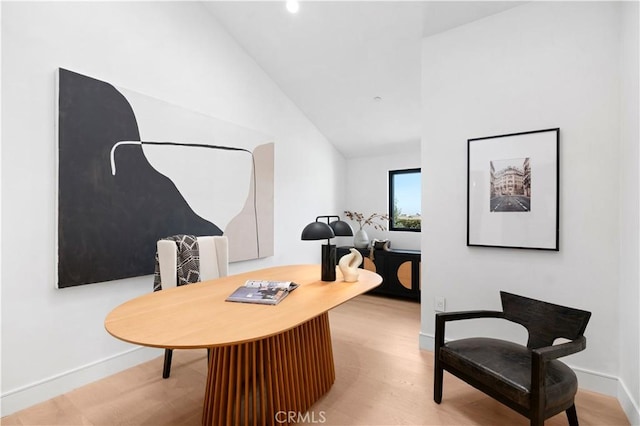 sitting room with wood-type flooring and high vaulted ceiling