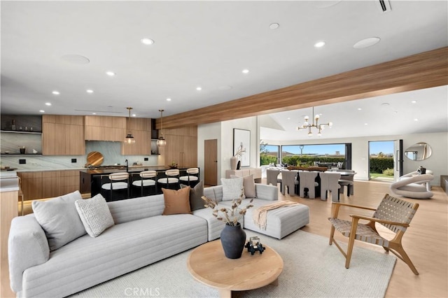 living room with a notable chandelier and light hardwood / wood-style floors