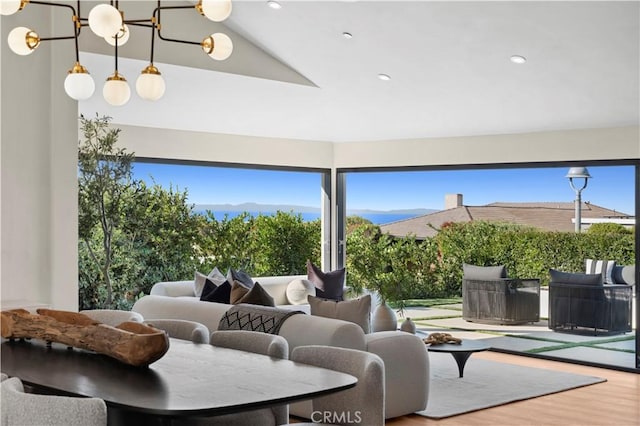 interior space with vaulted ceiling, wood finished floors, a mountain view, a chandelier, and recessed lighting