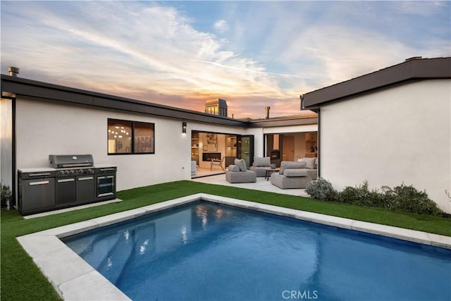 back of property at dusk with an outdoor living space, a lawn, an outdoor pool, a patio area, and stucco siding