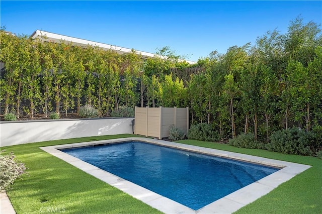outdoor pool with a lawn and fence