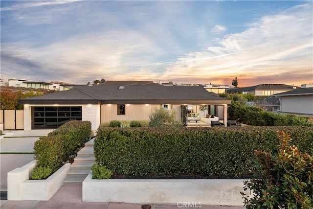 view of front of property with a garage, outdoor lounge area, and driveway