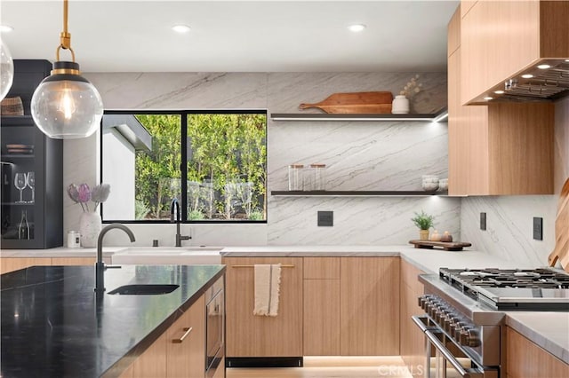 kitchen with sink, premium range hood, backsplash, high end stainless steel range, and decorative light fixtures