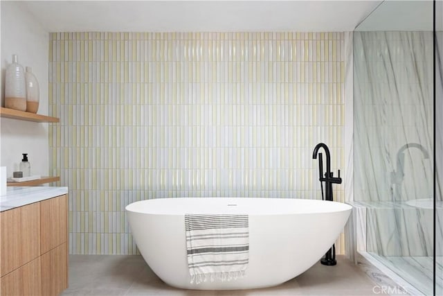 bathroom featuring vanity, separate shower and tub, and tile walls