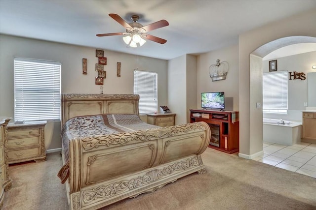 carpeted bedroom featuring ceiling fan and ensuite bath