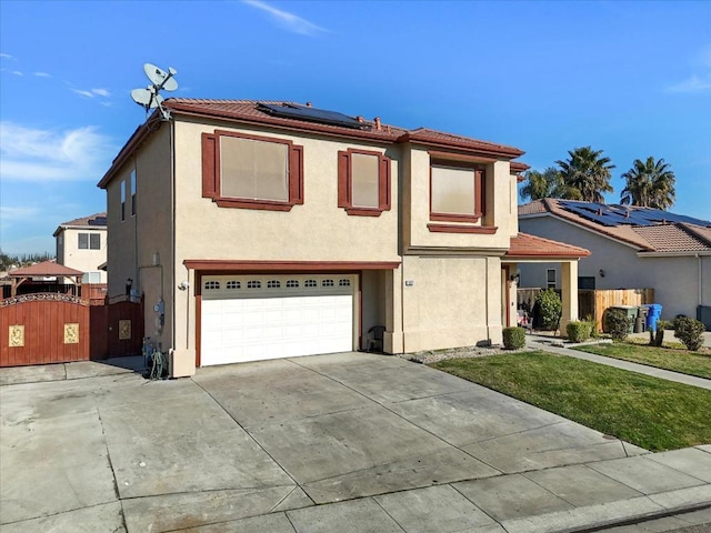 view of front of home featuring a garage, a front lawn, and solar panels