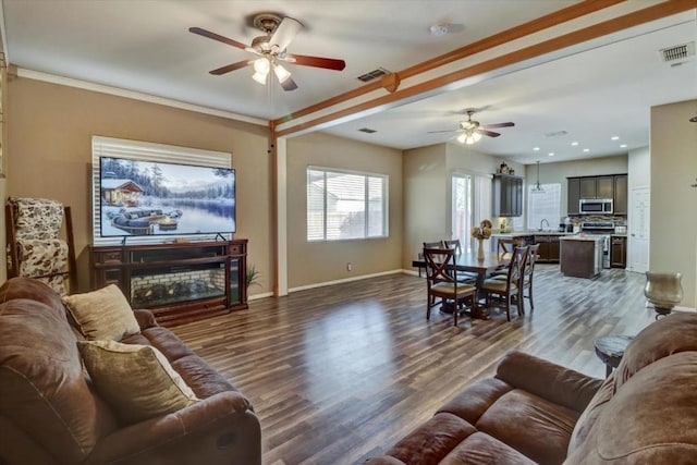 living room featuring crown molding, ceiling fan, and dark hardwood / wood-style floors