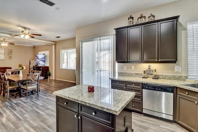 kitchen featuring dishwasher, light hardwood / wood-style floors, and light stone countertops