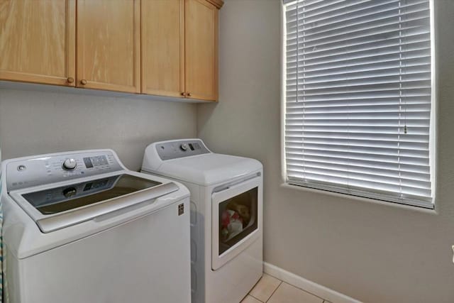 laundry area with light tile patterned flooring, cabinets, and washer and dryer