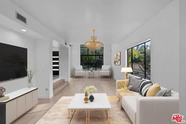 living room featuring light wood-type flooring and an inviting chandelier