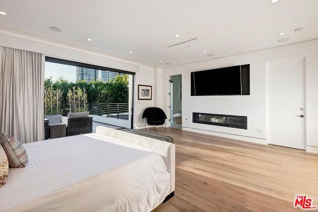 bedroom with access to exterior and light hardwood / wood-style flooring