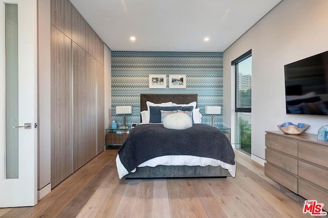 bedroom with light wood-type flooring and a closet