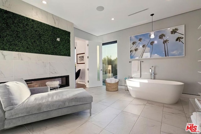 bathroom featuring a tub to relax in and a high end fireplace