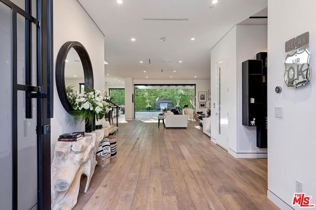 hallway featuring expansive windows and light wood-type flooring