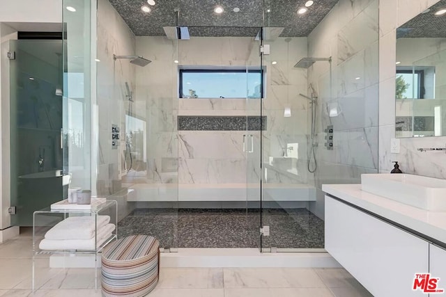 bathroom with walk in shower, vanity, tile walls, and a wealth of natural light