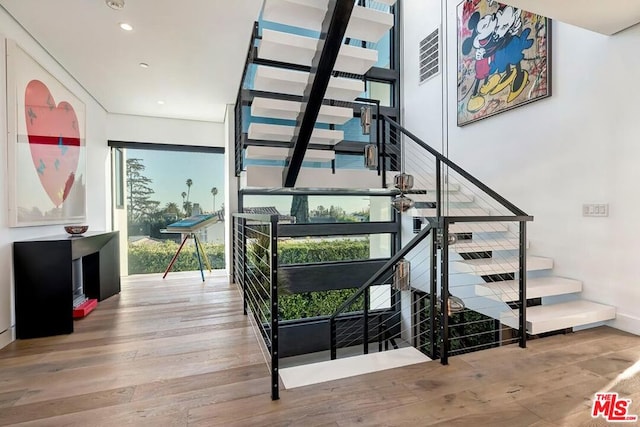 stairway featuring hardwood / wood-style flooring and a wealth of natural light