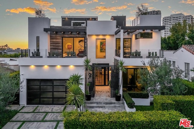 contemporary home featuring a garage and a balcony