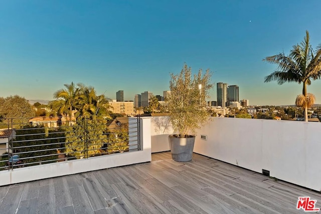 patio terrace at dusk featuring a balcony