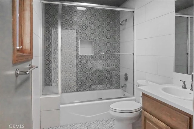 full bathroom featuring bath / shower combo with glass door, toilet, and vanity