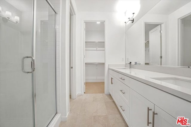 bathroom with a shower with door, tile patterned floors, and vanity