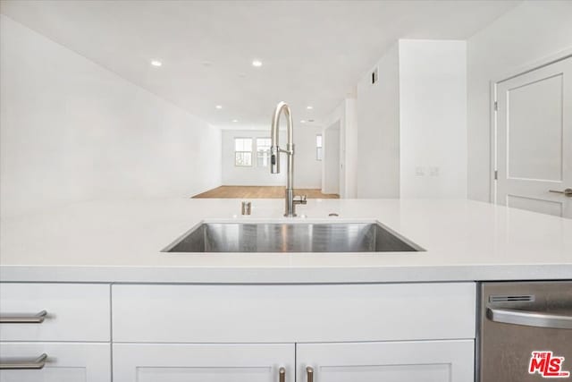 kitchen with sink, white cabinets, and dishwasher