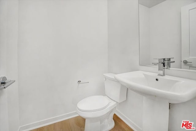 bathroom with hardwood / wood-style floors and toilet