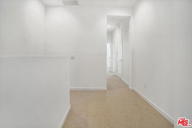 hall with light colored carpet