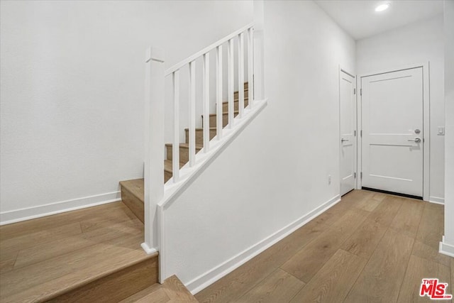 staircase with hardwood / wood-style flooring