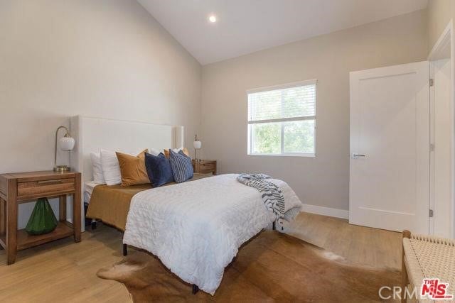 bedroom with lofted ceiling and hardwood / wood-style floors