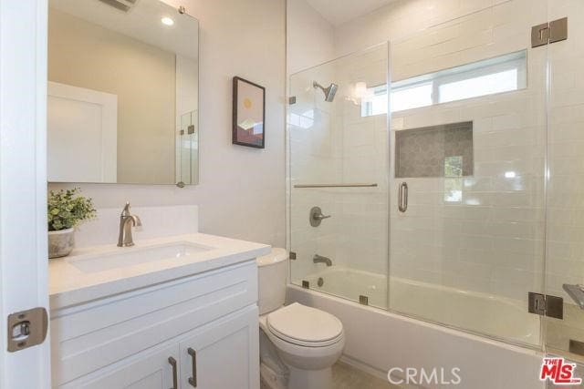 full bathroom with vanity, combined bath / shower with glass door, and toilet