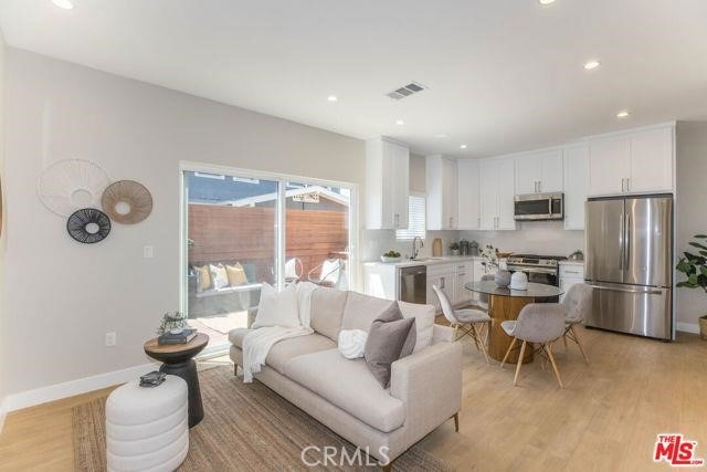 living room featuring sink and light hardwood / wood-style flooring