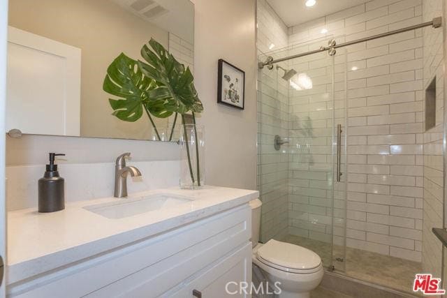 bathroom with vanity, toilet, and walk in shower