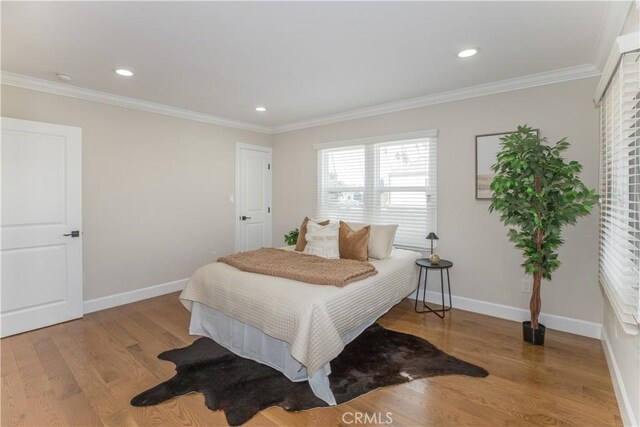 bedroom with crown molding and light wood-type flooring