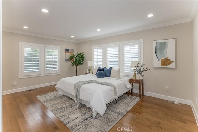 bedroom with ornamental molding, wood-type flooring, and multiple windows