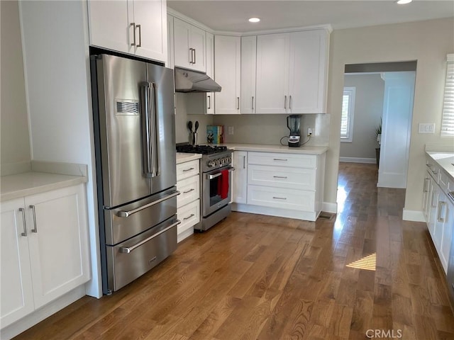 kitchen featuring white cabinets, dark hardwood / wood-style flooring, and high end appliances