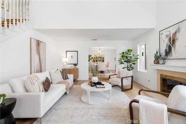 living room with light hardwood / wood-style floors and an inviting chandelier