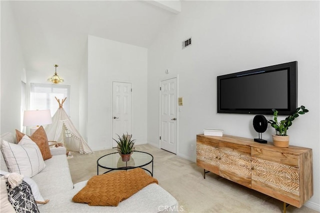 carpeted living room featuring beamed ceiling and high vaulted ceiling