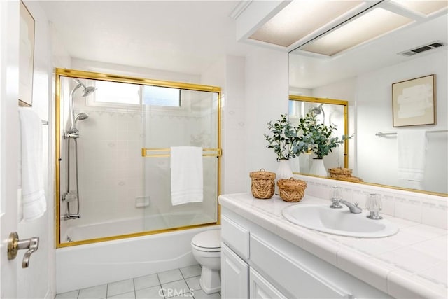 full bathroom with tile patterned flooring, vanity, enclosed tub / shower combo, and toilet