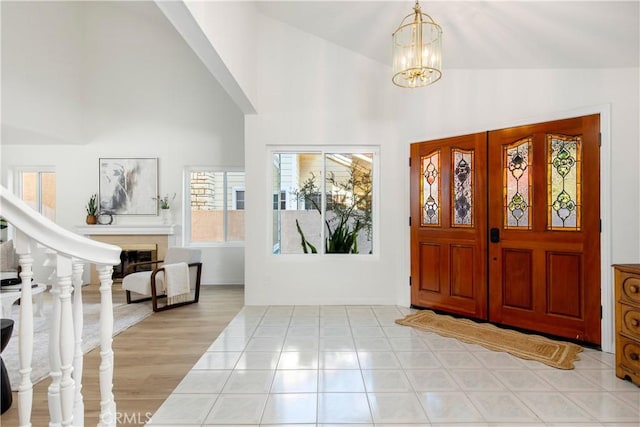 foyer with french doors, high vaulted ceiling, and a notable chandelier