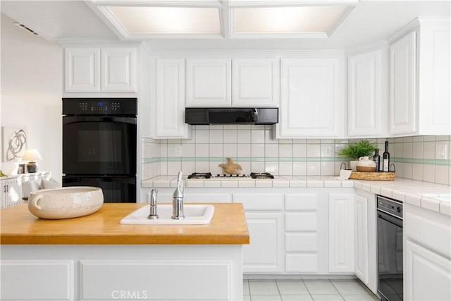 kitchen featuring double oven and white cabinets