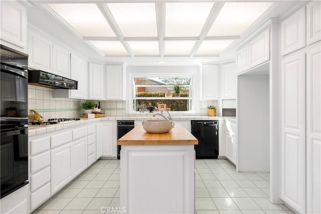 kitchen with a center island, white cabinets, black appliances, and wood counters