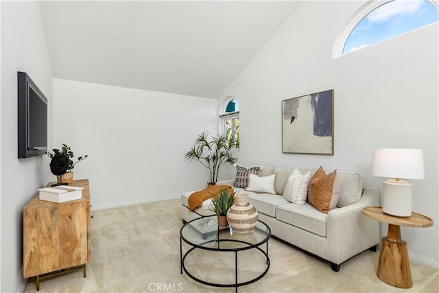 carpeted living room with high vaulted ceiling